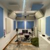 Blue and white ceiling baffles and wall panels in a music production room